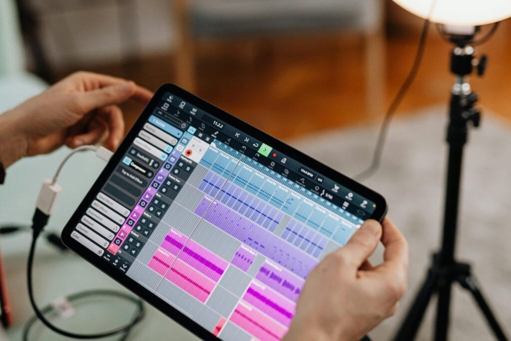 Close-up of hands holding a tablet showing music software, perfect for audio production themes.